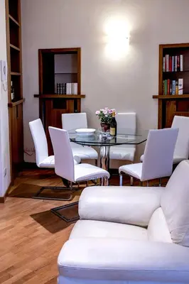 a dining room with a table and white chairs at Callimaco Domus in Rome
