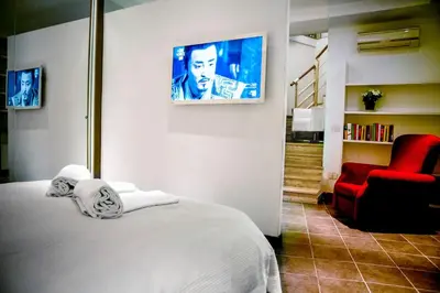 a bedroom with a bed and a red chair at Callimaco Domus in Rome