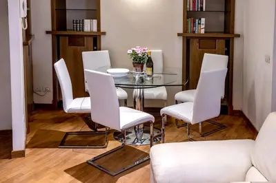 a dining room with a glass table and white chairs at Callimaco Domus in Rome