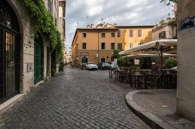 a cobblestone street with tables and chairs and buildings at Lungaretta Trastevere Penthouse Mimì & Cocò Home in Rome