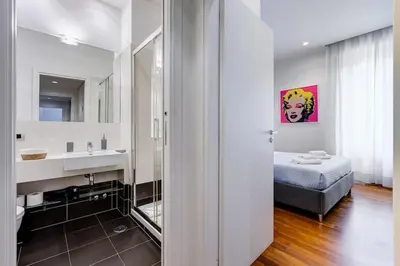 a bathroom with a sink and a bed and a mirror at Luxury Ludo House Trastevere in Rome
