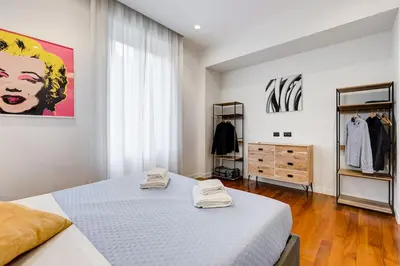a white bedroom with a bed and a dresser at Luxury Ludo House Trastevere in Rome