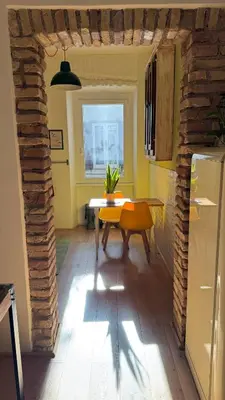a dining room with a table and a refrigerator at Quiet Loft Monteverde Roma in Rome