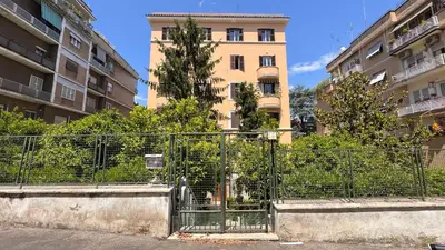 a fence in front of a tall building at Quiet Loft Monteverde Roma in Rome