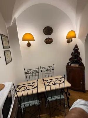 a kitchen with a table with chairs and lights on the wall at La casetta nel vicolo in Rome