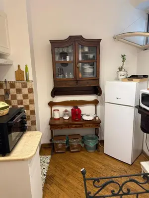a kitchen with a cabinet and a white refrigerator at La casetta nel vicolo in Rome