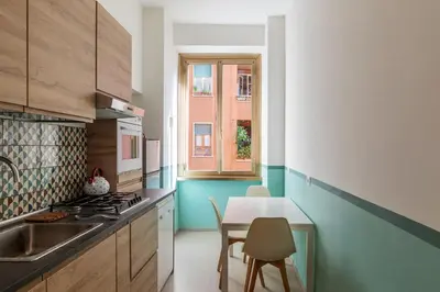a kitchen with a sink and a table with chairs at GuestHost - Comfy Apartment Garbatella Roma in Rome