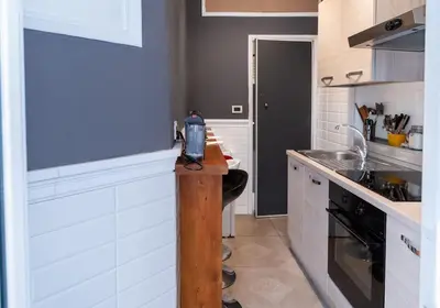 a kitchen with white cabinets and a counter top at Key Apartment Obelisco in Rome