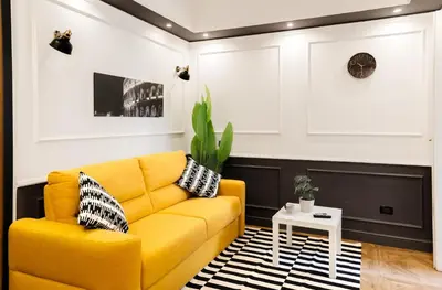 a living room with a yellow couch and a table at Key Apartment Obelisco in Rome