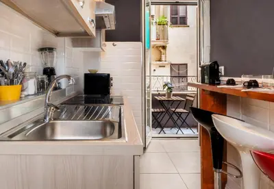 a kitchen with a stainless steel sink and a balcony at Key Apartment Obelisco in Rome
