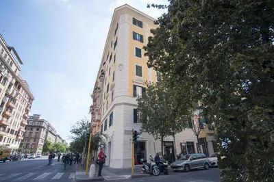 a tall yellow and white building on a city street at Rometobe in Rome