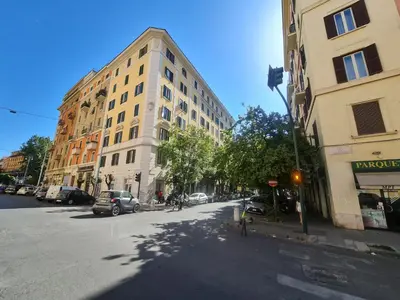 a tall building on a city street with cars parked at Rometobe in Rome