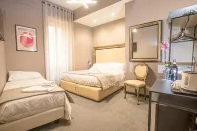 a hotel room with two beds and a mirror at Rometobe in Rome