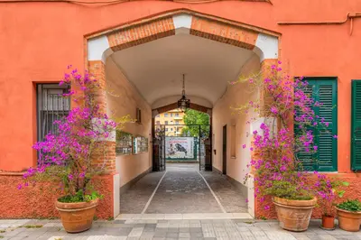an entrance to a building with purple flowers in pots at La terrazza al Cupolone in Rome