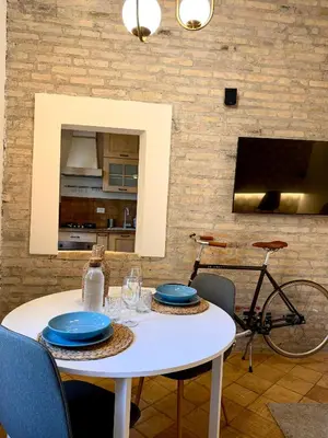 a white table with blue plates and a bike at Salotto34 in Rome
