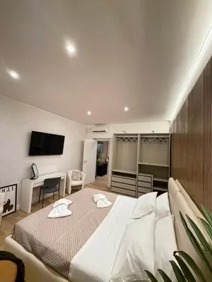 a bedroom with a large white bed and a desk at NAVONA MORGAN suite in Rome