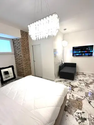 a bedroom with a white bed and a fireplace at Callas Luxury Apartment in Rome