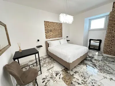 a bedroom with a bed and a desk and a chair at Callas Luxury Apartment in Rome