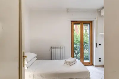 a white bedroom with a bed and a window at Lovely flat near Vaticano in Rome