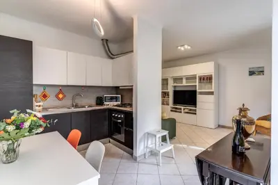 a kitchen with white cabinets and a table and chairs at Lovely flat near Vaticano in Rome