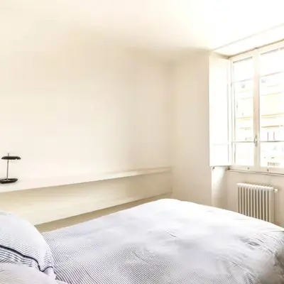 a white bedroom with a bed and a window at Monastery's View Home in Rome