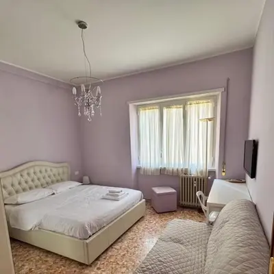 a bedroom with a bed and a couch and a chandelier at Colle Aurelio Home in Rome