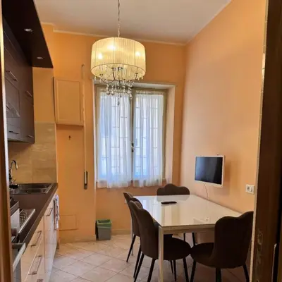 a kitchen with a table and chairs and a chandelier at Colle Aurelio Home in Rome