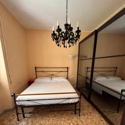 a bedroom with two beds and a chandelier at Colle Aurelio Home in Rome