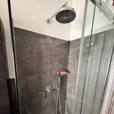 a shower with a glass door and a shower head at Colle Aurelio Home in Rome