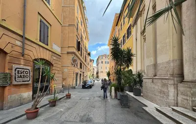 a person walking down a city street with buildings at Casa Mirella near Piazza Navona, Rooftop Views in Rome