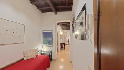 a living room with a red couch and a hallway at Casa Mirella near Piazza Navona, Rooftop Views in Rome