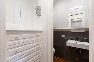 a bathroom with white cabinets and a sink at Amazing Vittoriano in Rome