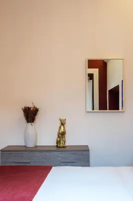 a dresser with a vase of flowers and a mirror at Casa Mia Trastevere in Rome