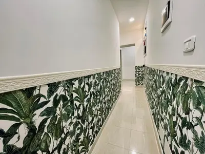 a hallway with green and white wallpaper on the walls at Cosmo Terzo GuestHouse Roma in Rome