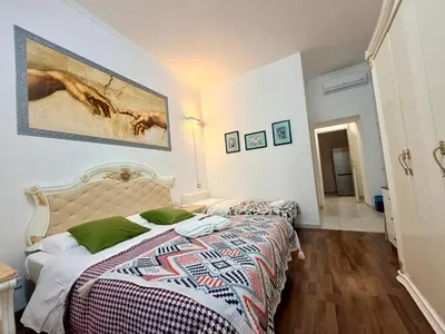 a bedroom with two beds and a painting on the wall at Cosmo Terzo GuestHouse Roma in Rome