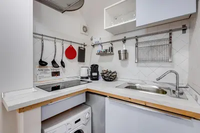 a white kitchen with a sink and a dishwasher at Colosseum Loft, Rustic-modern charm in Rome