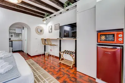 a room with a bed and a kitchen in a room at Colosseum Loft, Rustic-modern charm in Rome