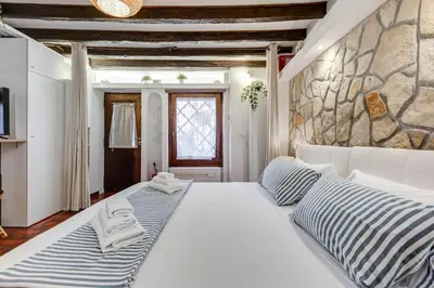 a bedroom with two beds and a stone wall at Colosseum Loft, Rustic-modern charm in Rome