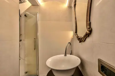 a bathroom with a white sink and a shower at Colosseum 1 Min Design Apt with Private Courtyard in Rome