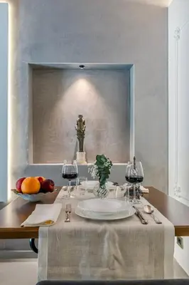 a table with two wine glasses and a plate of fruit at Colosseum 1 Min Design Apt with Private Courtyard in Rome
