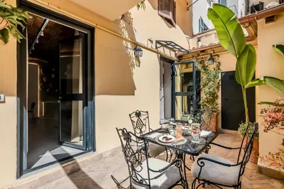 a patio with a table and chairs on a balcony at Colosseum 1 Min Design Apt with Private Courtyard in Rome