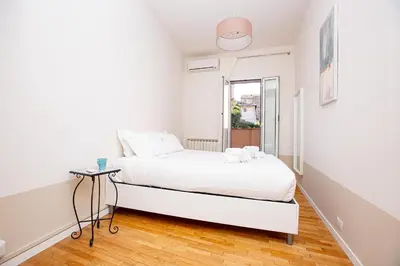 a white bedroom with a bed and a window at Zen 31 - Colosseum cozy apartment in Rome