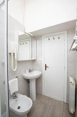 a white bathroom with a sink and a toilet at Zen 31 - Colosseum cozy apartment in Rome