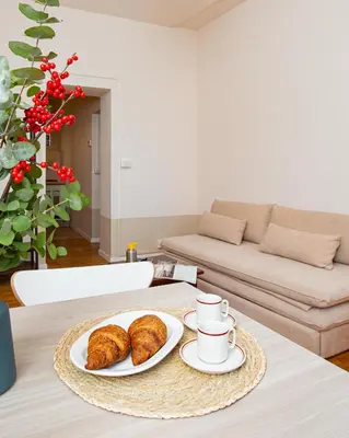 a table with a plate of croissants and coffee cups at Zen 31 - Colosseum cozy apartment in Rome