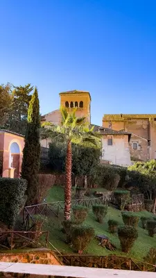 a courtyard with a palm tree and a building at Zen 31 - Colosseum cozy apartment in Rome