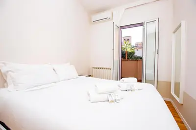 a white bed in a room with a window at Zen 31 - Colosseum cozy apartment in Rome