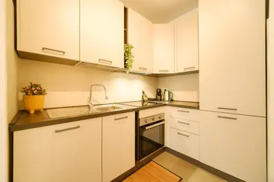a kitchen with white cabinets and a sink at Bonelli 67 Apartment in Rome