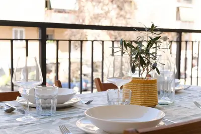 a table with plates and wine glasses on a balcony at Bonelli 67 Apartment in Rome