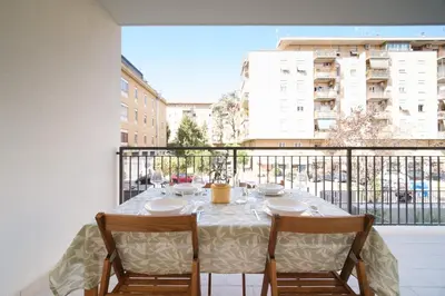 a table with two chairs sitting on a balcony at Bonelli 67 Apartment in Rome
