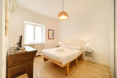 a bedroom with a bed and a desk and a window at Blue Apartment Testaccio & Trastevere in Rome